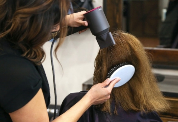 A person holding up a ball or hair